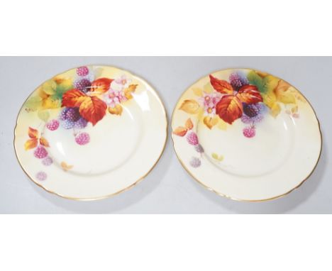 A pair of Royal Worcester lobed tea plates painted with autumnal leaves and berries by Kitty Blake, signed date mark 1935