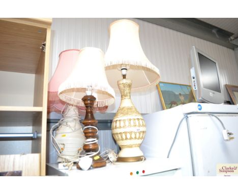 Two pottery table lamps and a turned wooden table lamp, all with shades 
