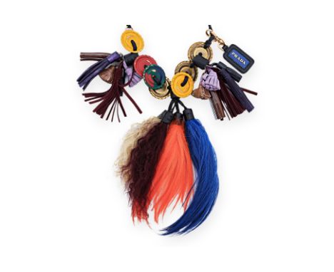 A PRADA NECKLACE Comprising a thin black leather strap threaded with leather, suede and faux fur tassels, painted brass discs