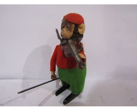 A Schuco clockwork monkey playing violin, with key 