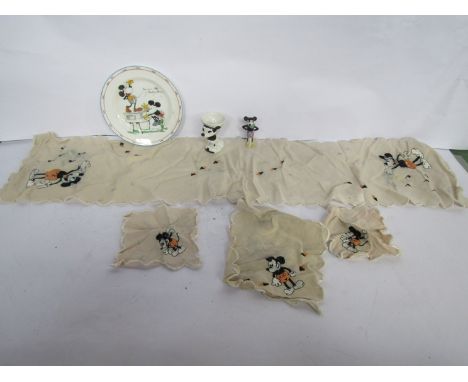 A vintage Mickey Mouse plate, figural egg cup and embroidered silk items 