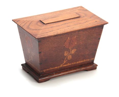 AN ARTS AND CRAFT INLAID OAK TEA CADDY of tapered form with moulded hinged top above a floral inlaid front 19.5cm wide 12.5cm