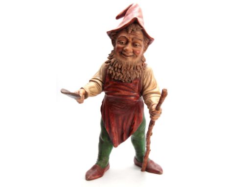 A LARGE EARLY 20TH CENTURY EASTERN EUROPEAN POLYCHROME PAINTED TERRACOTTA STANDING GNOME holding a trowel and stick 76cm high