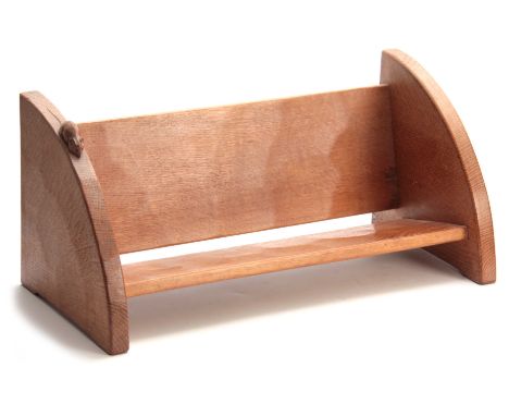 A ROBERT MOUSEMAN THOMPSON OAK BOOK TROUGH of adzed form with curved ends and carved mouse trademark 45cms wide