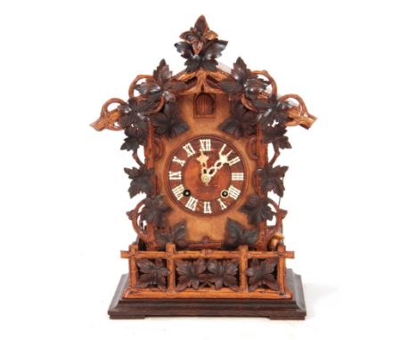 A LATE 19th CENTURY BLACK FOREST CUCKOO CLOCK the architectural pediment with carved leaf decoration above a matching oak cas