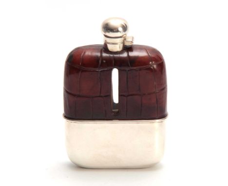 AN EARLY 20th CENTURY OVERSIZED SILVER AND CROCODILE SKIN HIP FLASK having a hinged bayonet fit lid and removable silver cup 