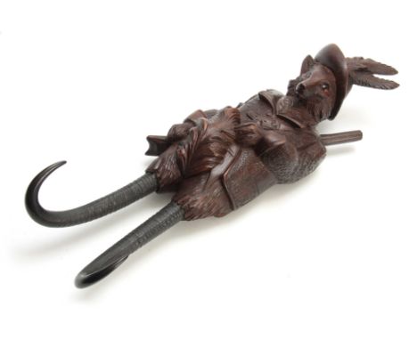 A LARGE LATE 19th CENTURY MUSICAL CARVED BLACK FOREST COAT HOOK modelled as a well-dressed fox with amber glass eyes and two 