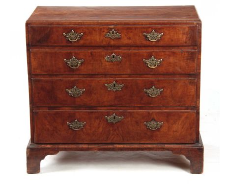 A GEORGE I WALNUT CHEST OF DRAWERS with a caddy moulded top above four graduated drawers fitted with pierced brass handles; s