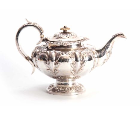 A VICTORIAN SILVER TEAPOT OF LARGE SIZE of circular footed form with hinged lid and leaf capped handle, the body and spout em
