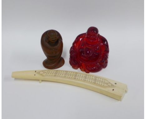Faux amber Buddha, 11cm, and a fruitwood figure together with a modern faux ivory cribbage board (3) 