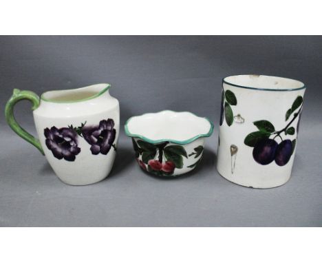 Wemyss ware pottery to include a jug with pansies pattern, bowl with plums and a tankard (handle lacking) (a/f) 15 x 12cm (3)