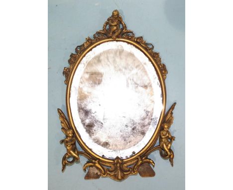 An early-20th century gilt-brass oval strut mirror, the foliate frame applied with three cherubs, 25 x 18cm, a trivet, a bugl