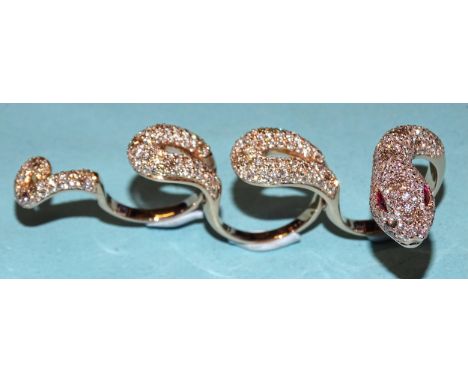 An impressive four-finger ring in the form of a snake pavé-set white diamonds interspersed with clusters of brown diamonds to