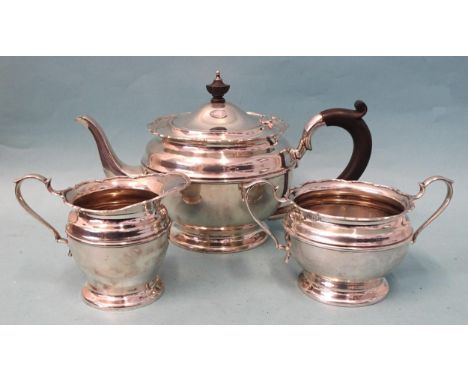 A George V Mappin &amp; Webb silver three-piece tea service of circular form with wavy rim, comprising teapot, sugar bowl and