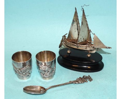 A pair of Chinese silver tots decorated with a dragon, 4.3cm high, marked WH90 for Wang Hing, 60g, ___1.9oz an Asian small si
