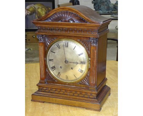 An early-20th century walnut mantel clock with architectural-form case, convex silvered dial and twin-train, gong-striking mo