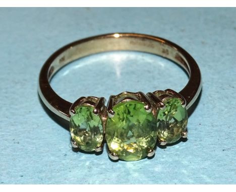 A 9ct gold ring set three oval peridots, size O, 2.4g. 