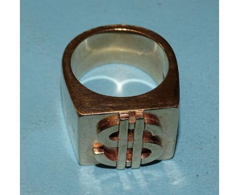 A very large yellow gold ring with raised dollar sign, marked '9ct', size Z+, 62.9g. 