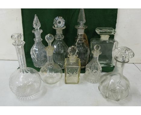  Shelf containing a quantity of various 19th C &amp; later Cut Glass Decanters including one large Chanel 