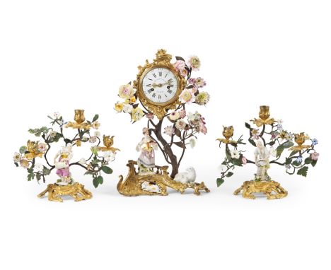 Garniture Louis XV comprenant une pendule en bronze doré, figure en porcelaine Meissen et fleurettes de Vincennes, et une pai