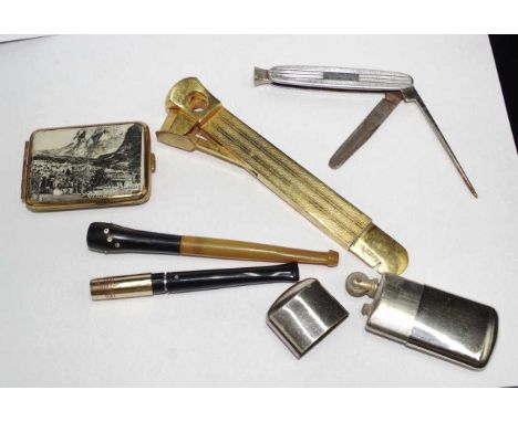 Quantity of various smoking implements including cigar cutters,a match strikers,a lighter, and cigarette holders