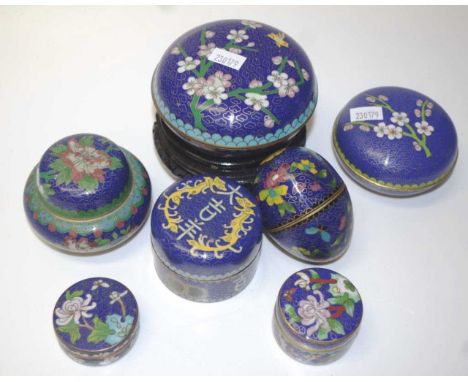 Seven various Chinese cloisonne trinket boxes with floral and blue decorations, together with a wooden stand