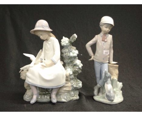 Two Nao porcelain figurines including a young boy with a dog, and a seated young lady with doves