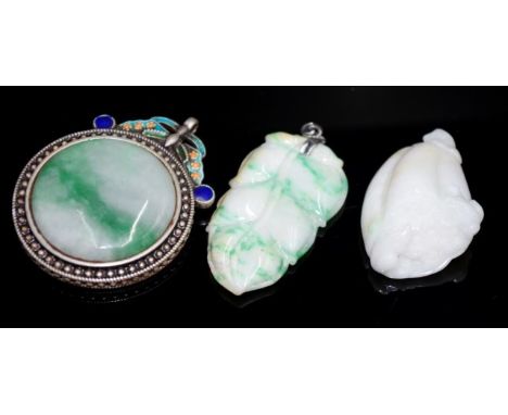 Three various Chinese carved jade pendants including: circular green jade pendant, in decorated enamel frame; leaf form penda