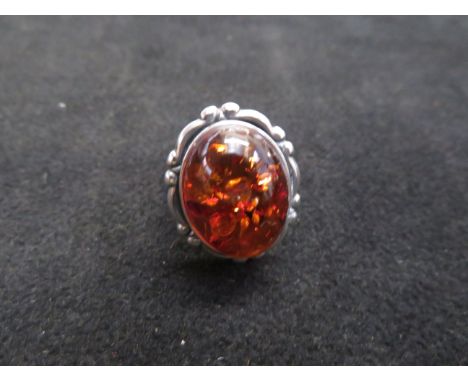 Silver dress ring set with large amber stone