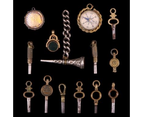 Four early 20th Century and later breloques comprising a bloodstone, carnelian and base metal swivel seal, a magnetic compass