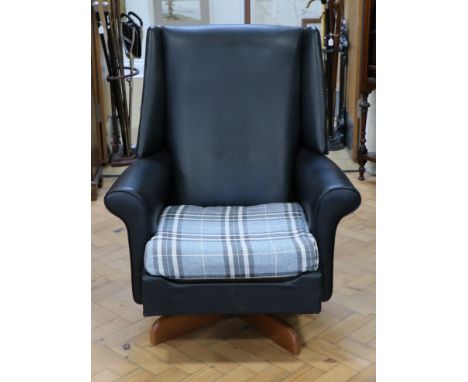 A 1960s black leatherette upholstered wing-back swivel easy armchair, having a Pirelli patent rubber seat suspension and a sp