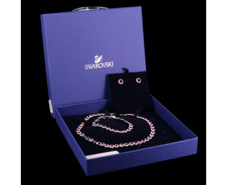 A Swarovski parure, comprising a ruby red and white "gem" necklace, bracelet and stud earrings, in original case with documen