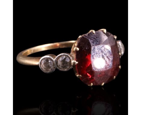 A vintage garnet and white stone dress ring comprising a central cushion-cut stone of approx 9 x 9 mm claw-set between pairs 
