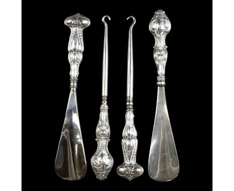 An early 20th Century Art Nouveau silver handled shoe horn and button hook set, together with a similar pair