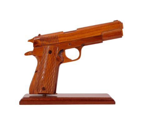 A finely-executed carved wooden 1:1 scale model of a Colt M 1911 automatic pistol, with stand,