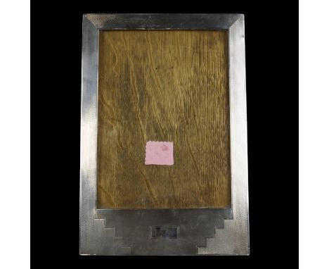 A 1930s Art Deco silver photograph frame, of planar form decorated with geometric engine-turning, 30 cm x 20 cm