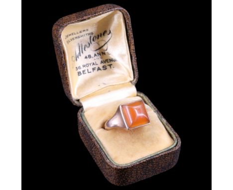 A 1930s carnelian and 9 ct rose gold pinkie ring, comprising a square cushion cabochon bezel-set between tapering shoulders, 