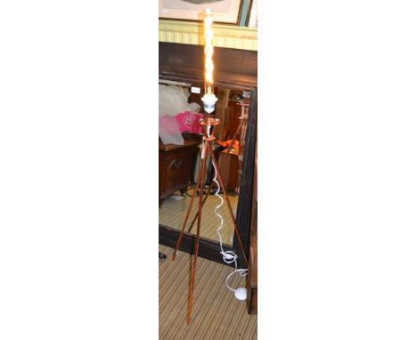 Modern copper coloured tri-pod floor lamp with a filament bulb