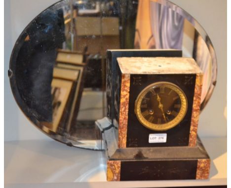 A French slate mantel clock and an oval wall mirror