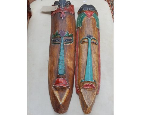 A pair of polychrome painted carved wood elongated heads, together with a southern African carved and polished hardstone abst