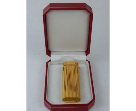 A gilt Cartier lighter, with inset diamond. 