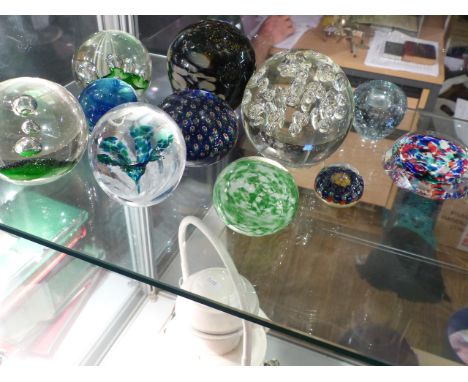 A collection of eleven glass paperweights, includes Caithness. 