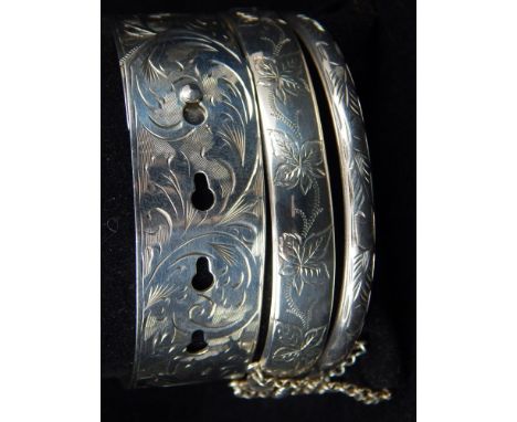 A silver Charles Horner bangle, together with a smaller Charles Horner example, and a silver bangle, all with engraved floral