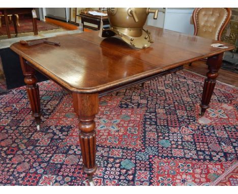 A Victorian mahogany extending dining table, the rectangular moulded top with a leaf insertion above an winding mechanism, on