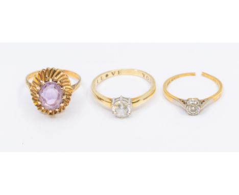 A collection of three stone set gold rings, to include a cubic zirconia 9ct gold solitaire, size S, along with an amethyst ov