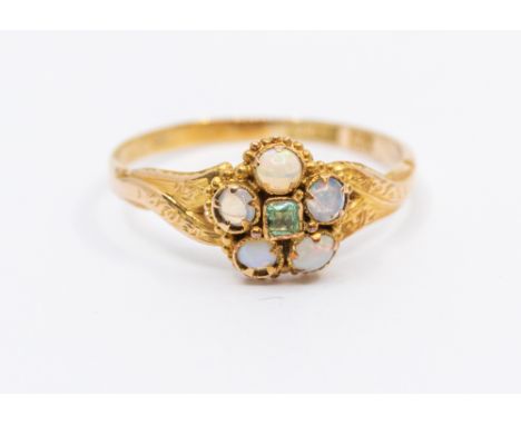 A Victorian emerald and opal 15ct gold ring, comprising a flower motif set to the centre with a small emerald within a border