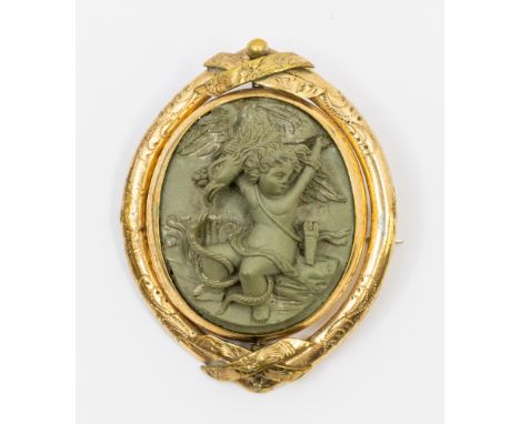 A Victorian gilt metal finely carved lava stone brooch, oval form depicting a mythical scene of a cherub, snake and bird, wit