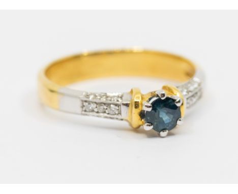 A sapphire and diamond 18ct  gold ring, comprising a round mixed cut sapphire approx 4mm, claw set to diamond set shoulders e