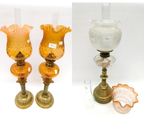 A collection of brass stemmed oil lamps, to include a pair of late Victorian brass stemmed oil lamps with glass oil compartme