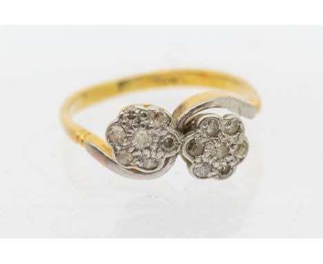 A diamond and 18ct gold flower cluster ring, comprising a double flower cluster platinum set with small diamonds, cross over 